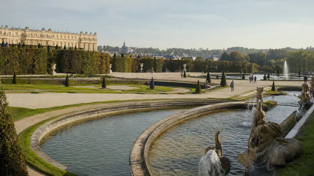 Versailles Theatre Grove with flowing water channels, sculpted greenery and historic palace architecture in soft morning light